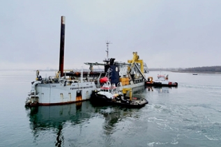 Baggerschiff mit zwei Schleppern auf dem Wasser Baggerschiff mit zwei Schleppern auf dem Wasser